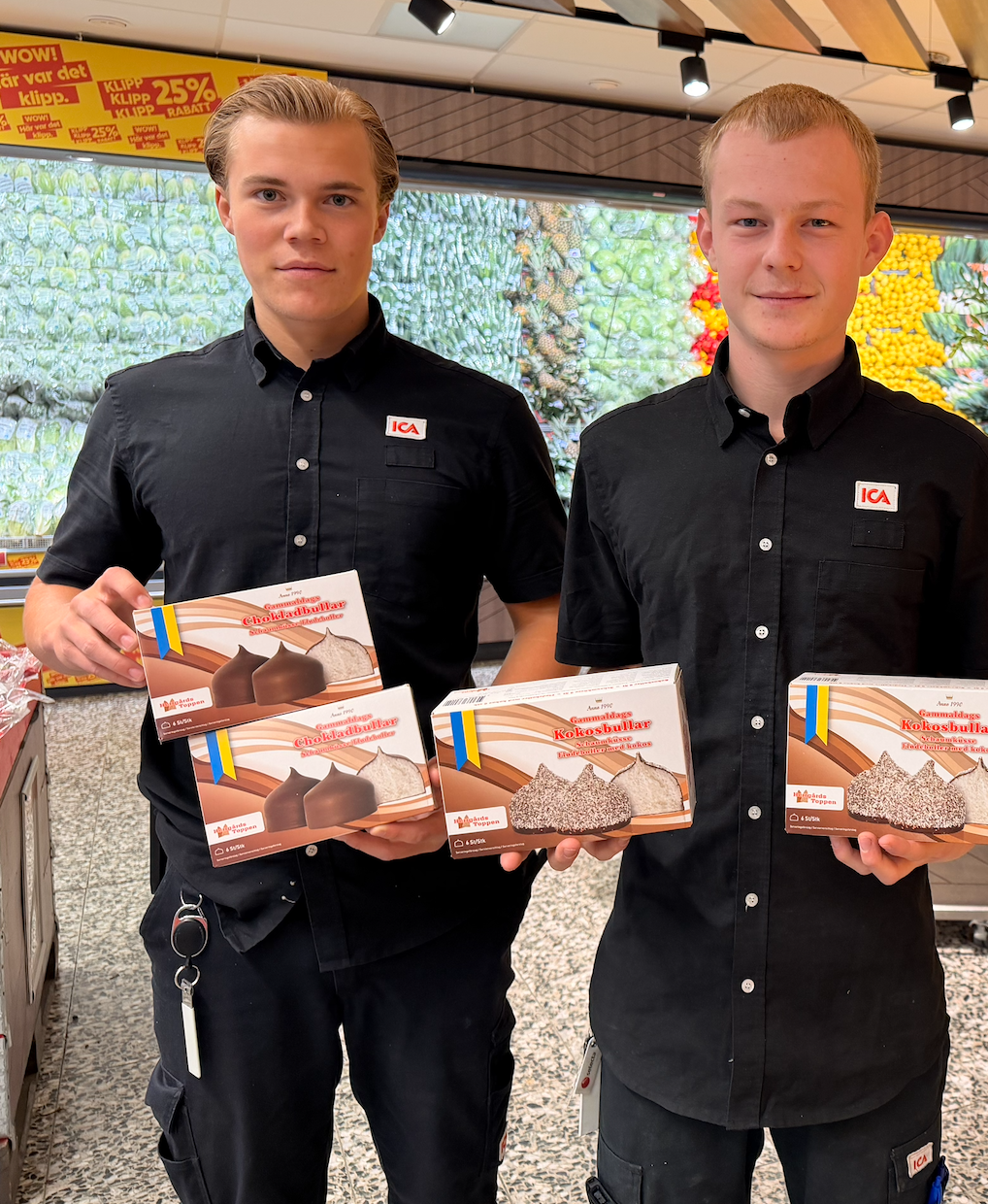 Två ICA-medarbetare håller upp Herrgårdstoppens kokosbollar i butikens frukt- och grönsaksavdelning.