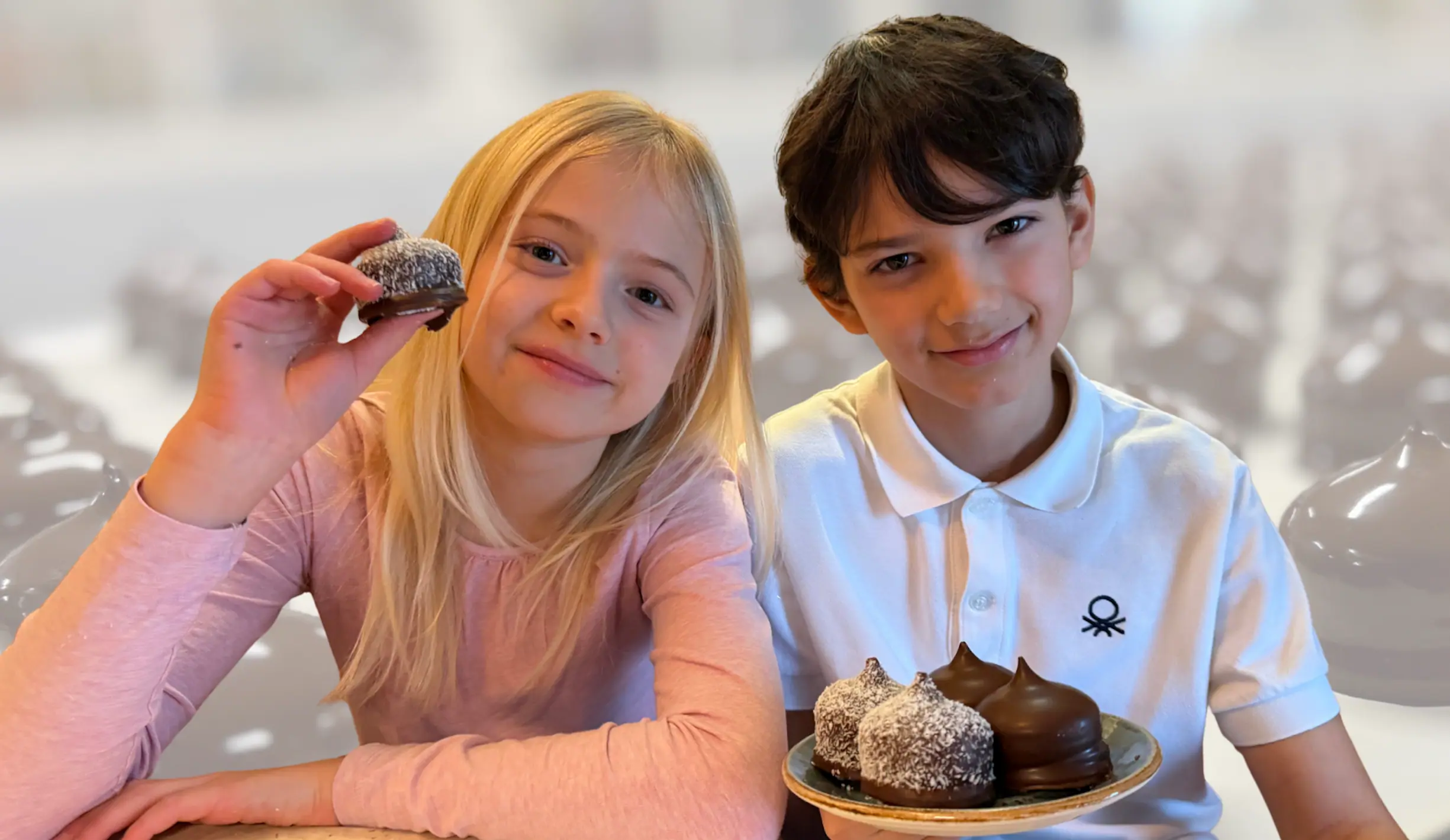 Två barn som njuter av Herrgårdstoppens kokosbollar på ett café